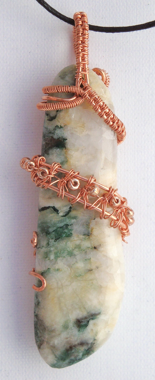 White and green stone wrapped with copper wire