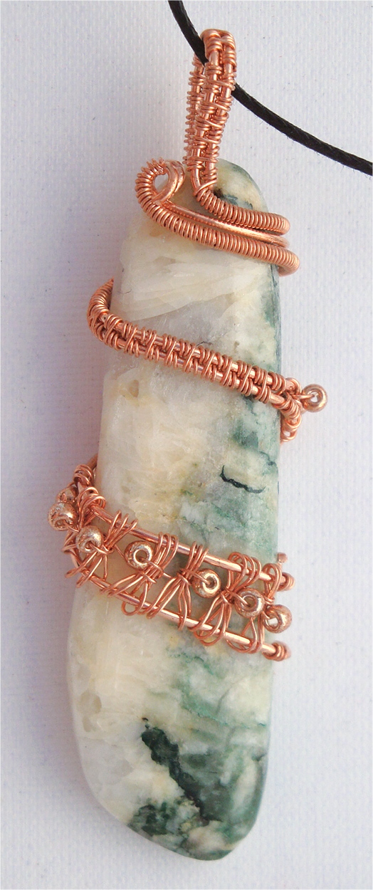 White and green stone wrapped with copper wire