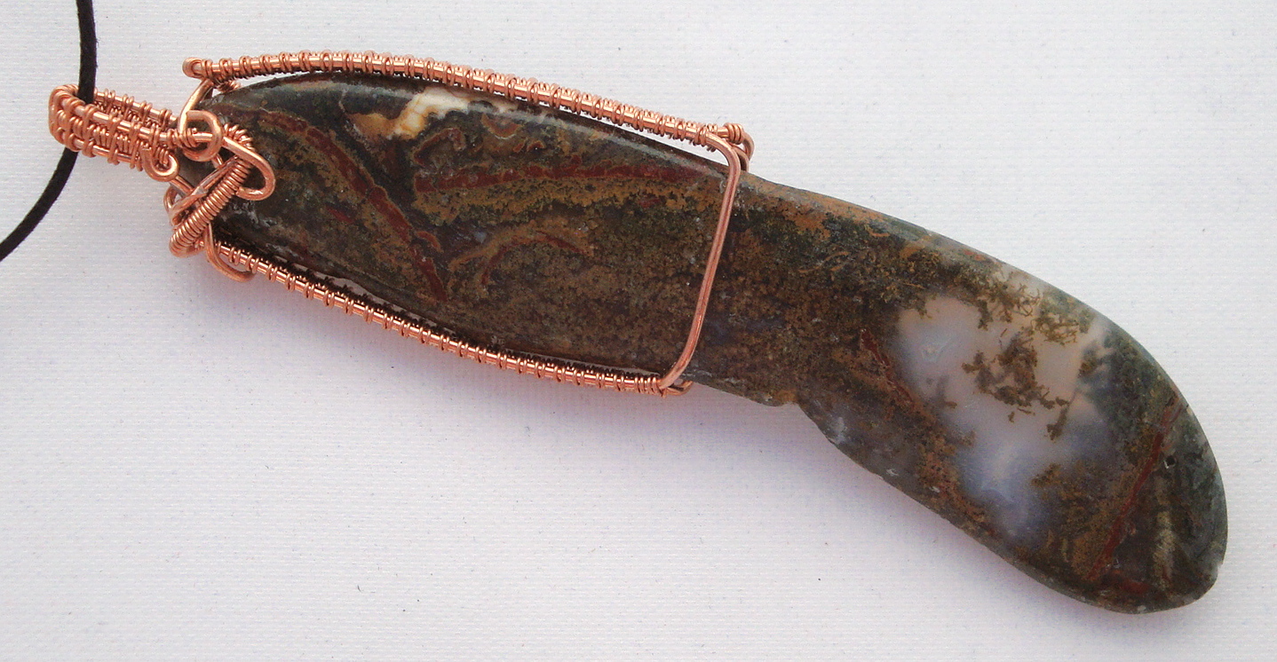 Long brown stone wrapped with copper wire