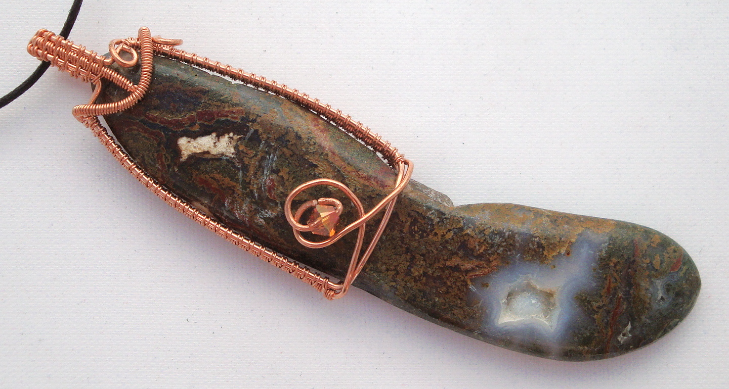 Long brown stone wrapped with copper wire