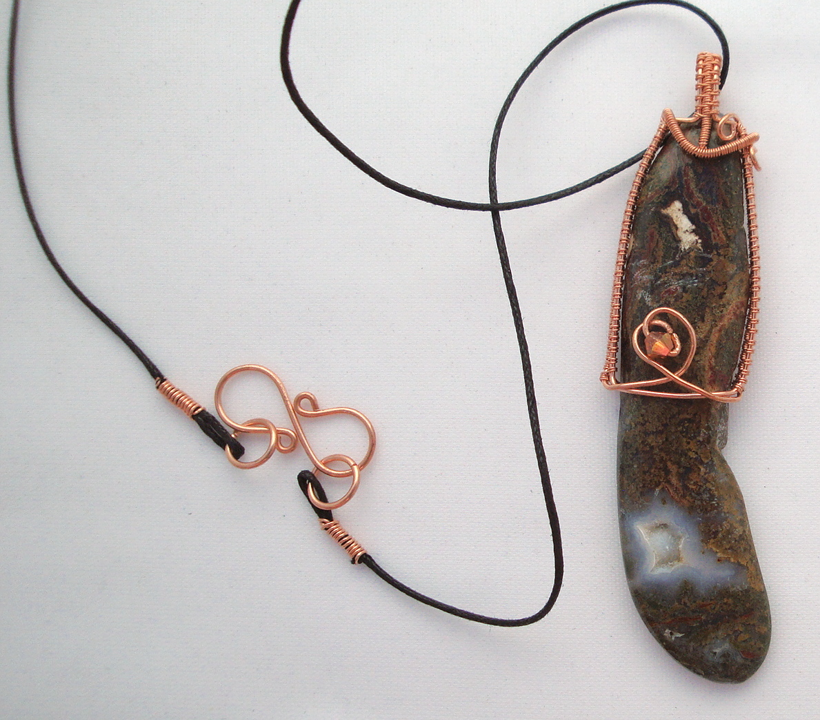 Long brown stone wrapped with copper wire