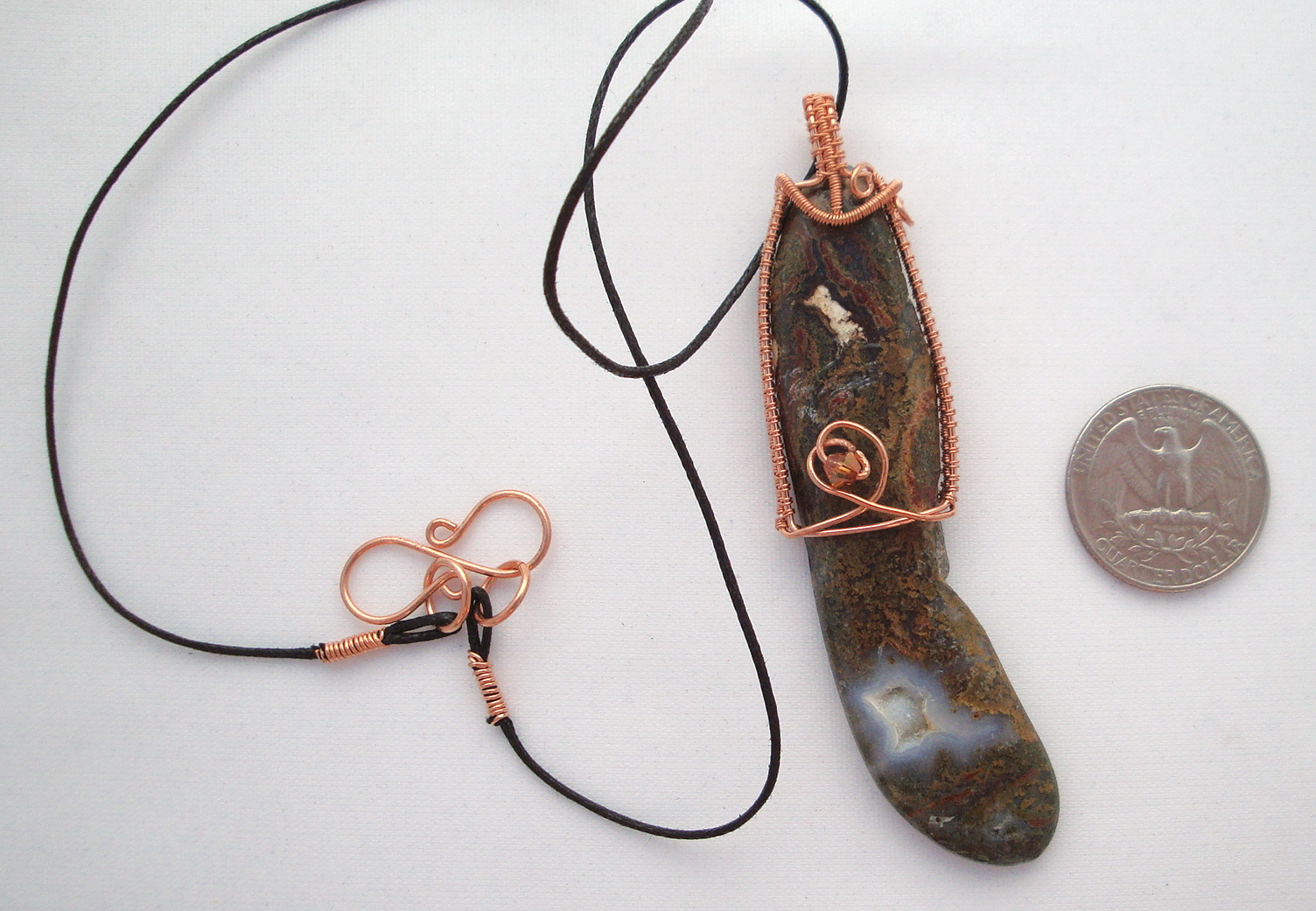 Long brown stone wrapped with copper wire