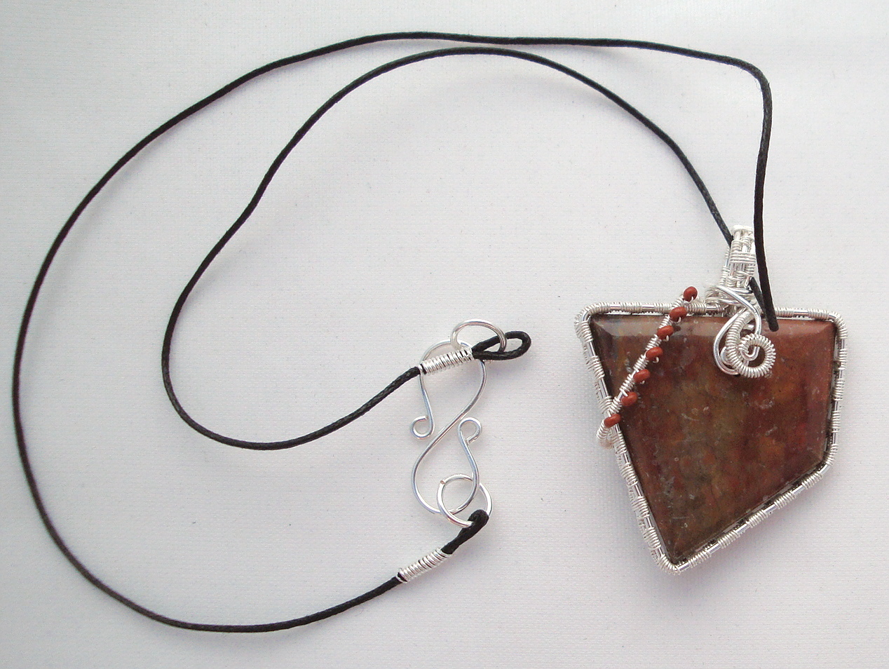 Reddish-brown stone wrapped with silver wire