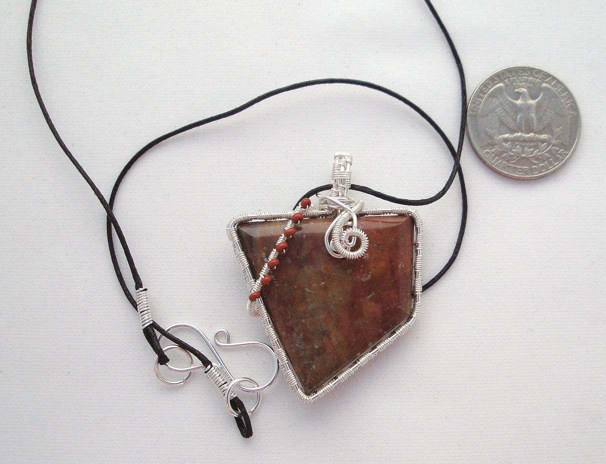 Reddish-brown stone wrapped with silver wire