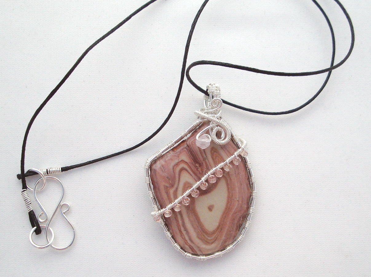 Pink-white swirled stone wrapped with silver wire