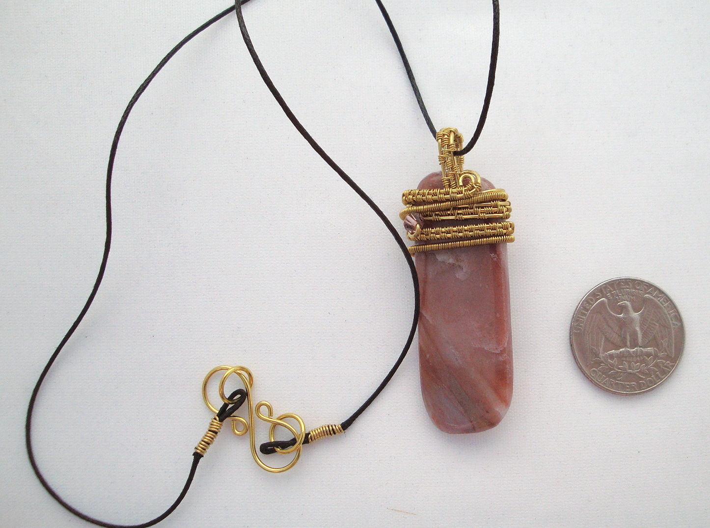 Pink striped stone wrapped with bronze wire