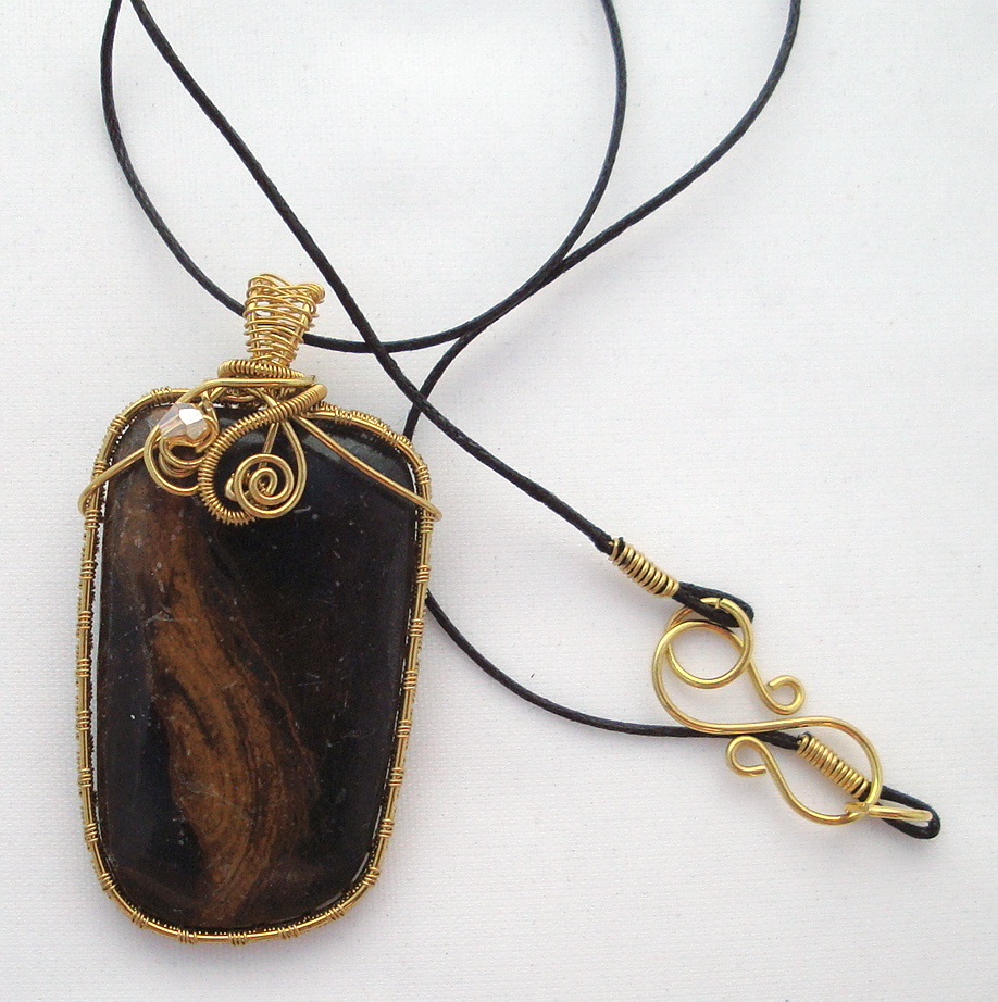 Black stone with brown swirls wrapped with bronze wire