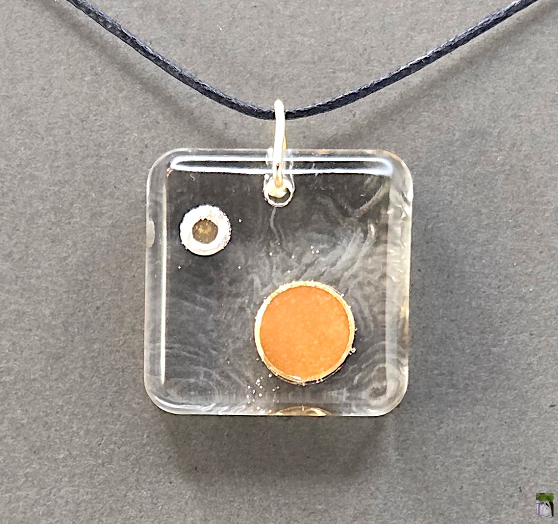Small resin pendants with color inclusions.