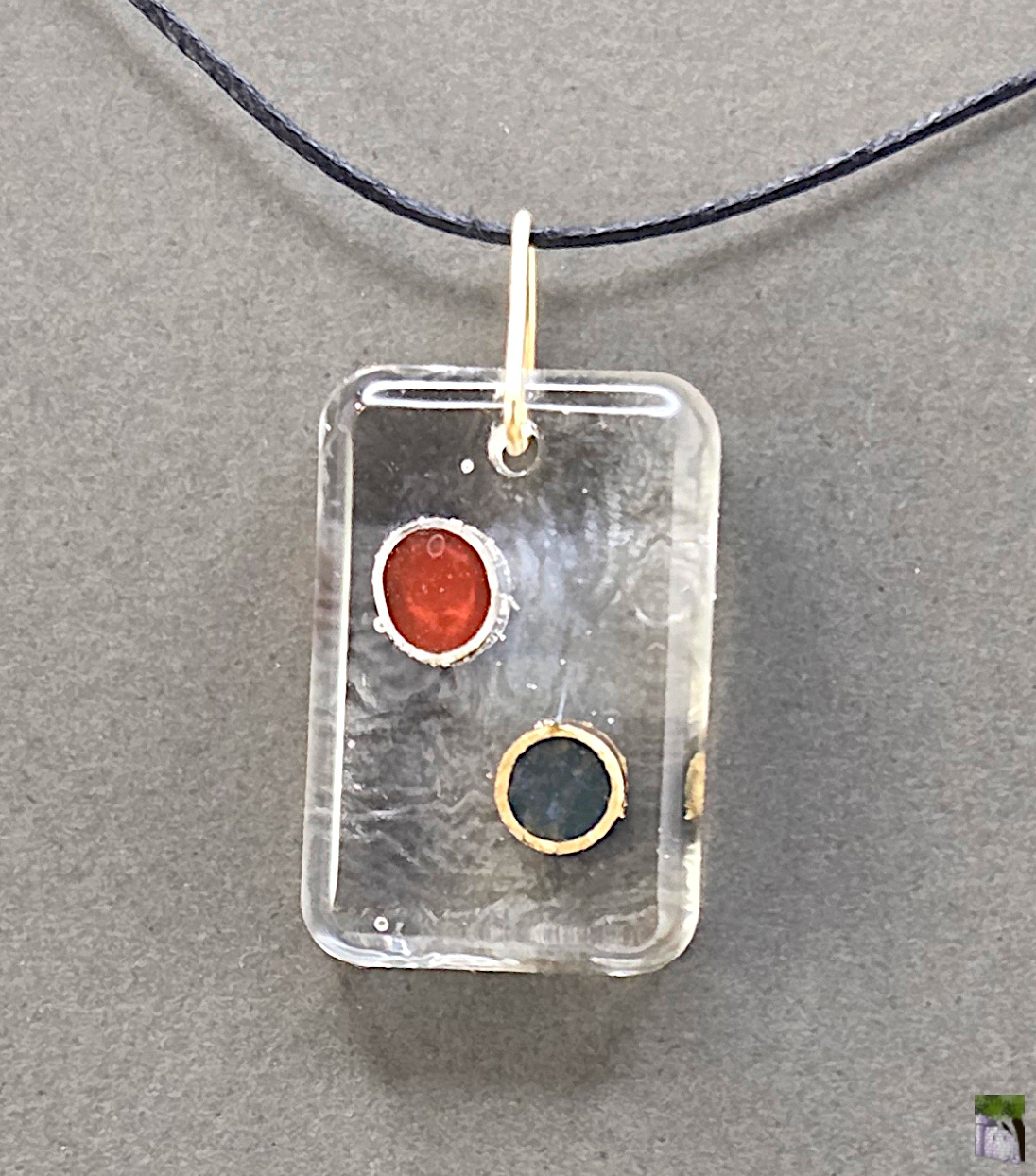 Small resin pendants with color inclusions.