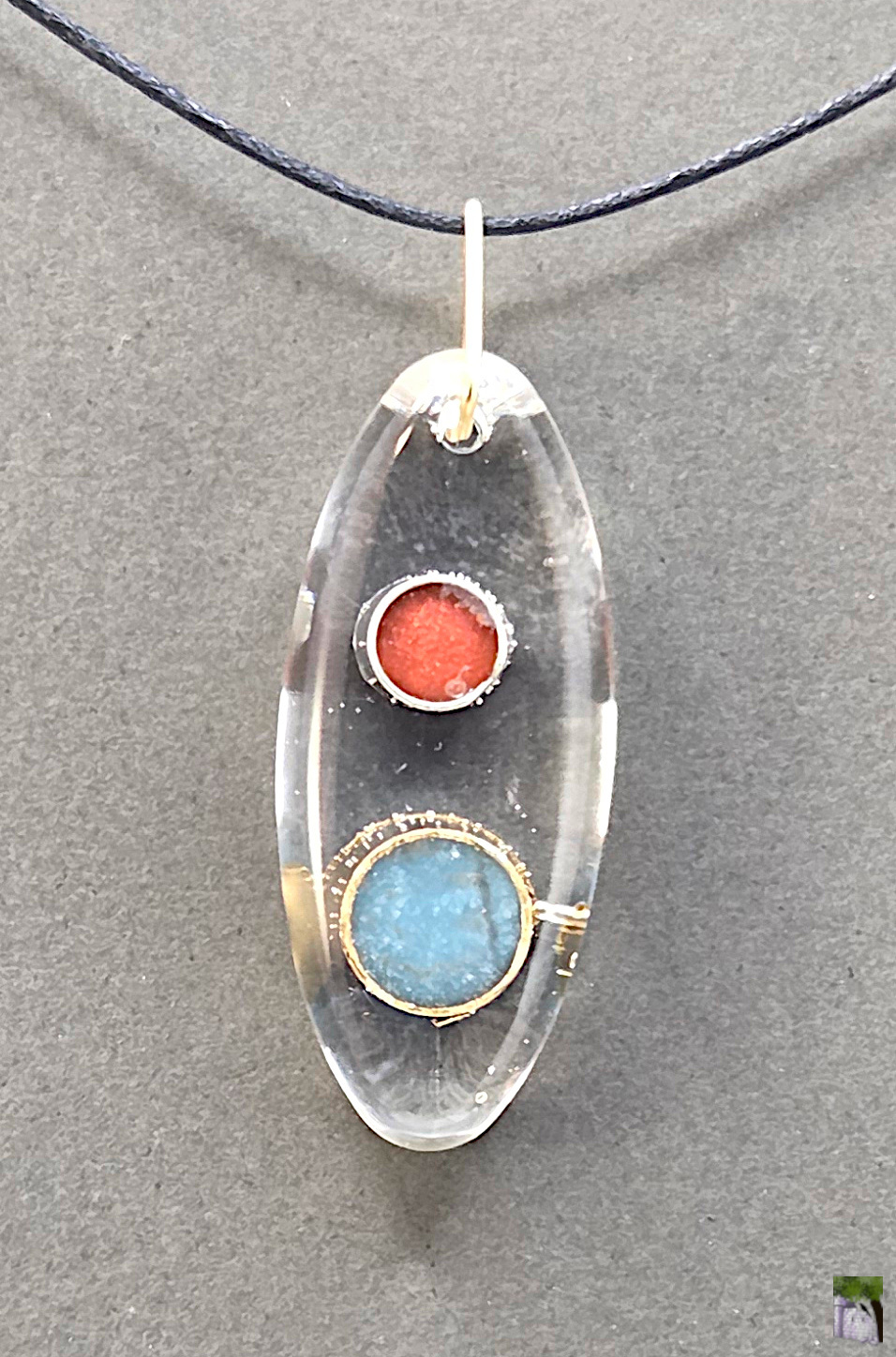 Small resin pendants with color inclusions.