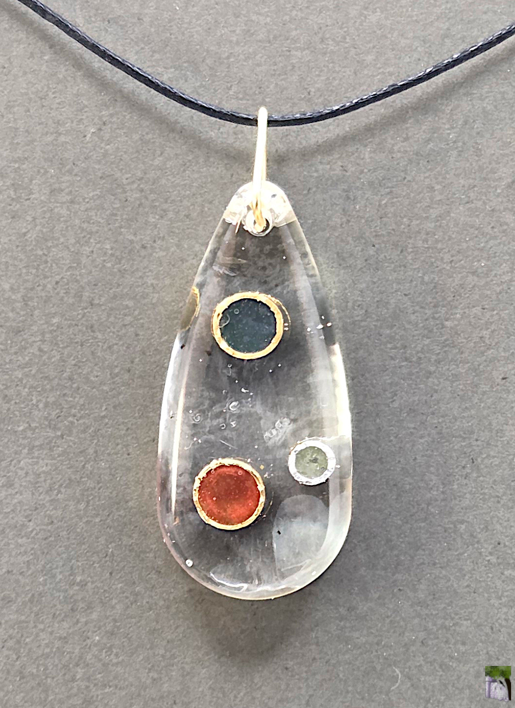 Small resin pendants with color inclusions.