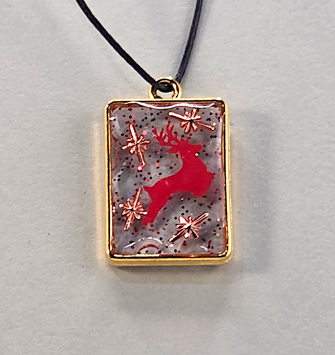 Resin pendants using bronze open bezels and red figures.