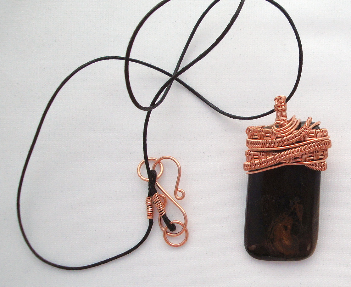 Black stone with brown swirls wrapped with copper wire