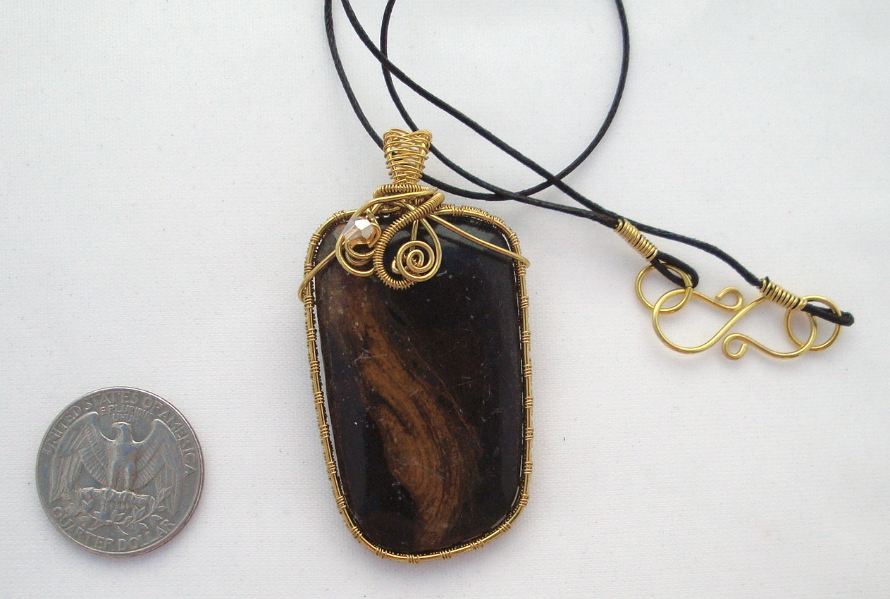 Black stone with brown swirls wrapped with bronze wire